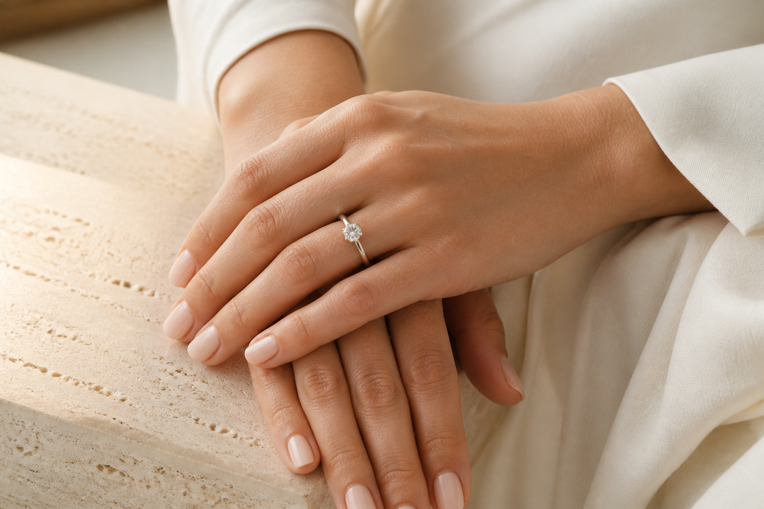 Woman wearing a solitaire engagement ring while resting both hands