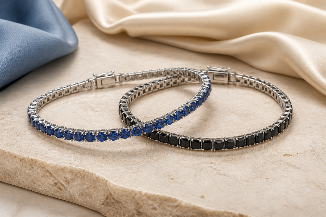 Blue and black stone tennis bracelets arranged together on warm ivory stone