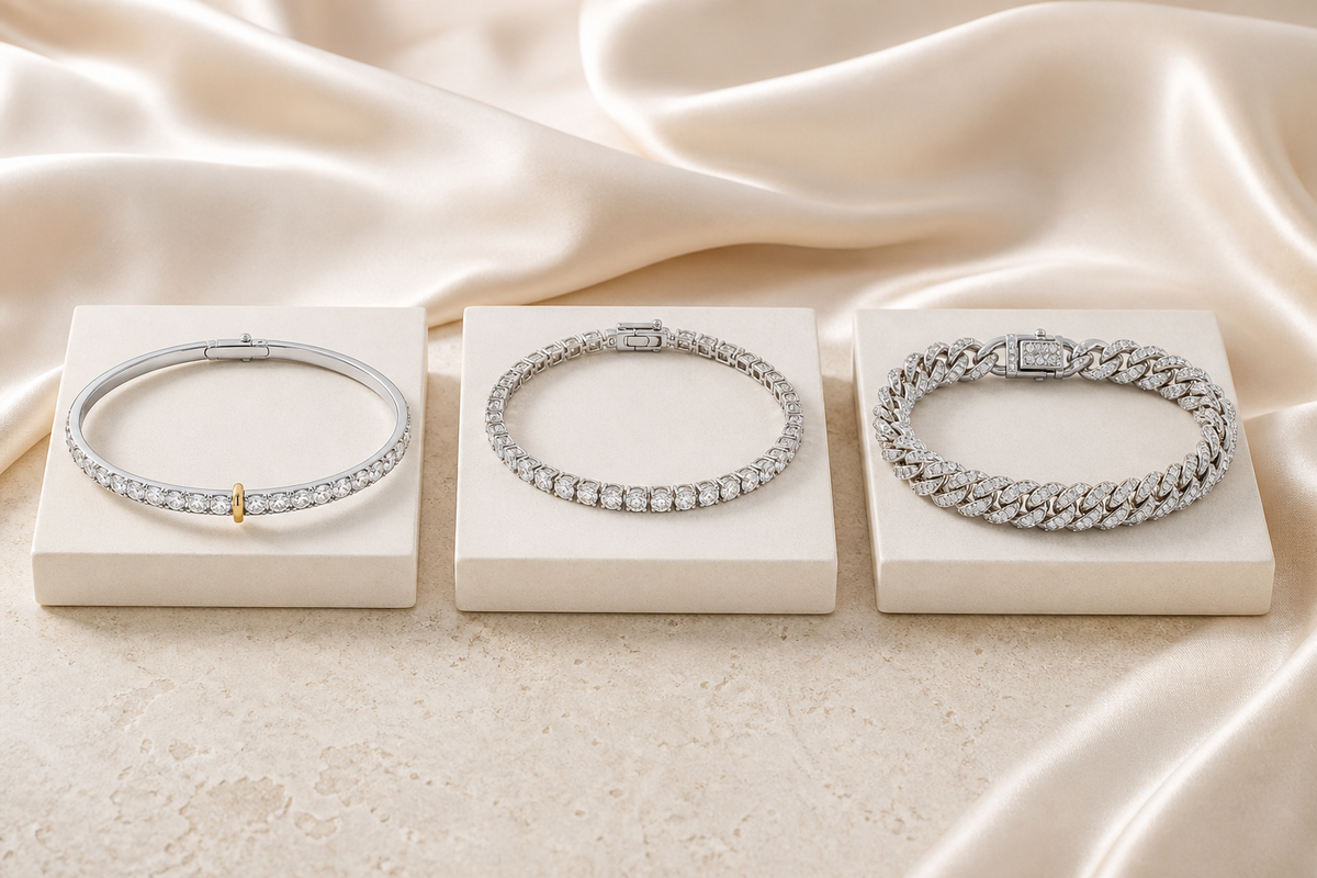 Bangle, tennis bracelet and Cuban link bracelet displayed side by side on ivory stands