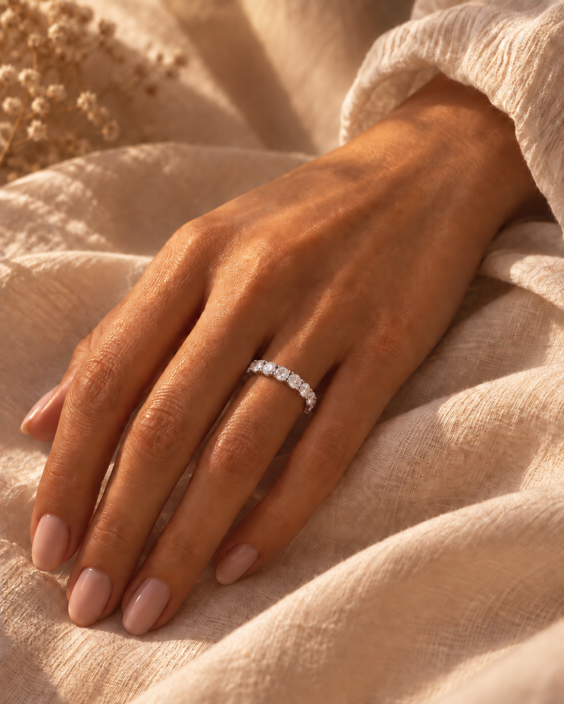 Woman wearing the Ashley round moissanite full eternity ring in warm natural light