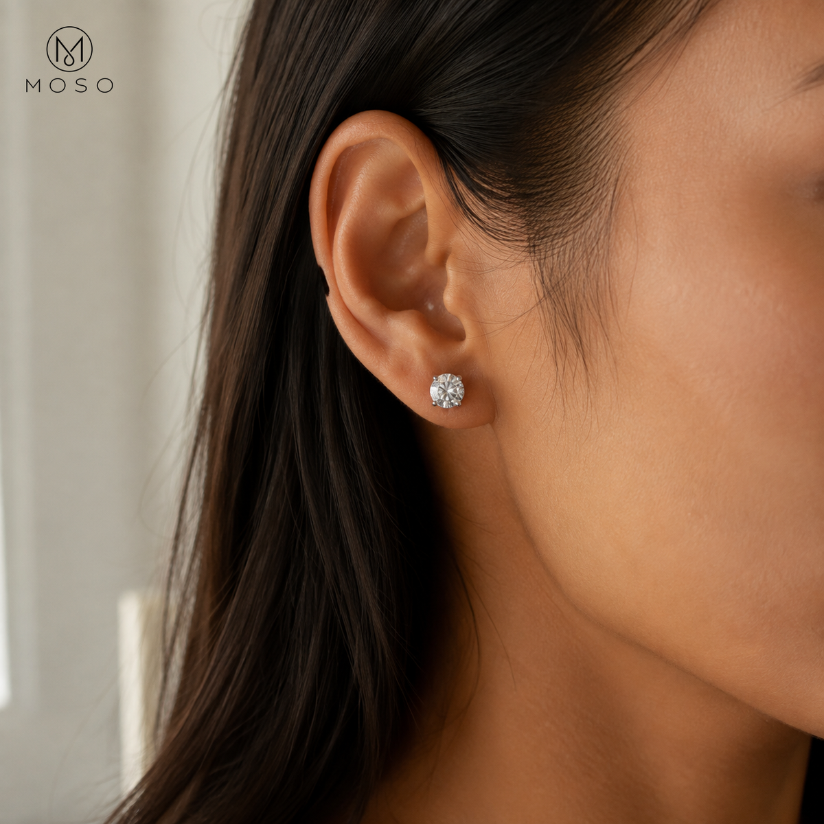Amelia silver tone round moissanite stud earring worn on the ear