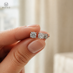 Amelia round moissanite stud earring pair held for scale