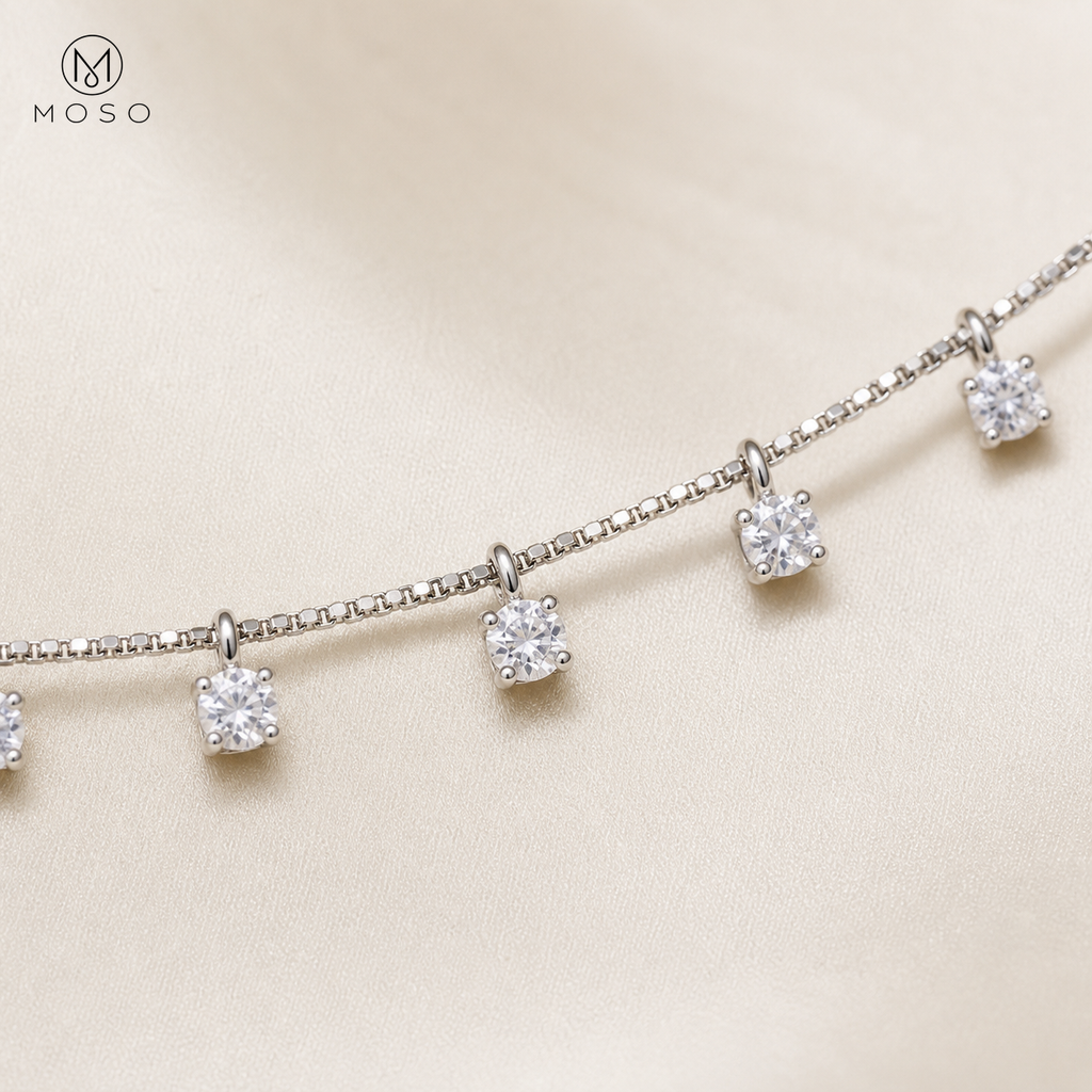 Round moissanite drop stations and fine silver chain macro detail