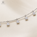 Round moissanite drop stations and fine silver chain macro detail