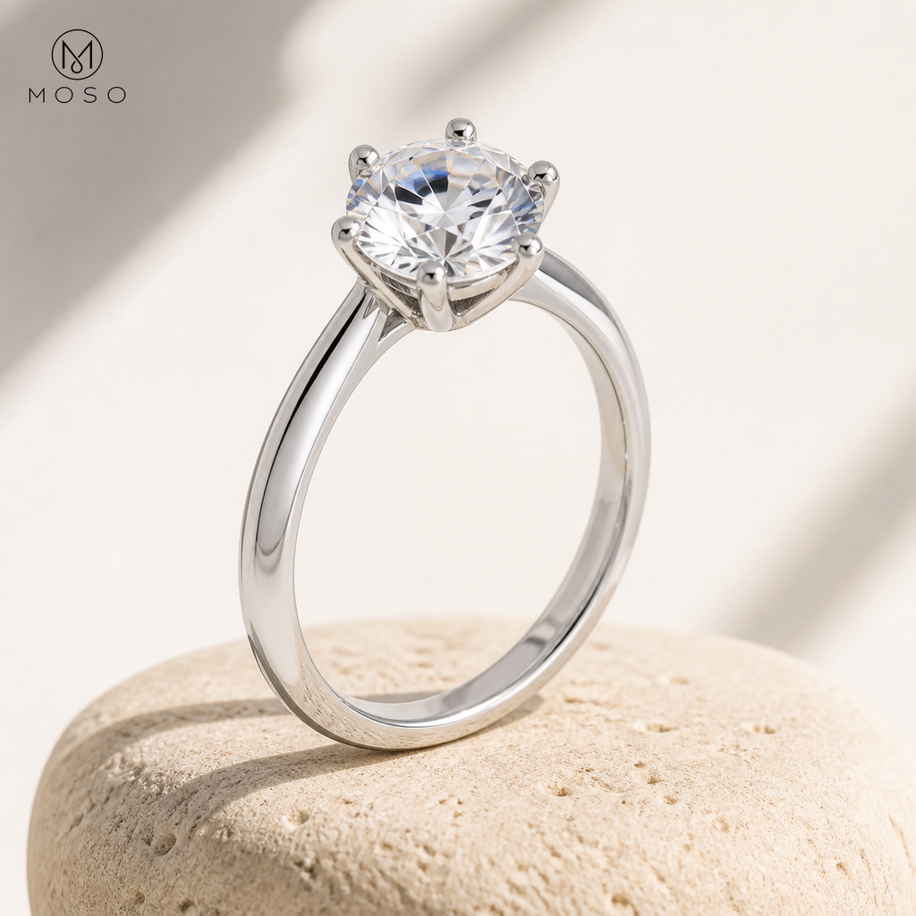 Charlotte silver moissanite solitaire ring on beige pedestal