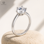 Charlotte silver moissanite solitaire ring on beige pedestal
