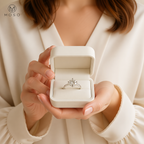 Woman holding Charlotte round moissanite ring in ivory box