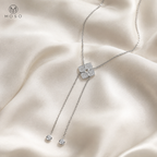 Chloe moissanite lariat necklace arranged on ivory silk