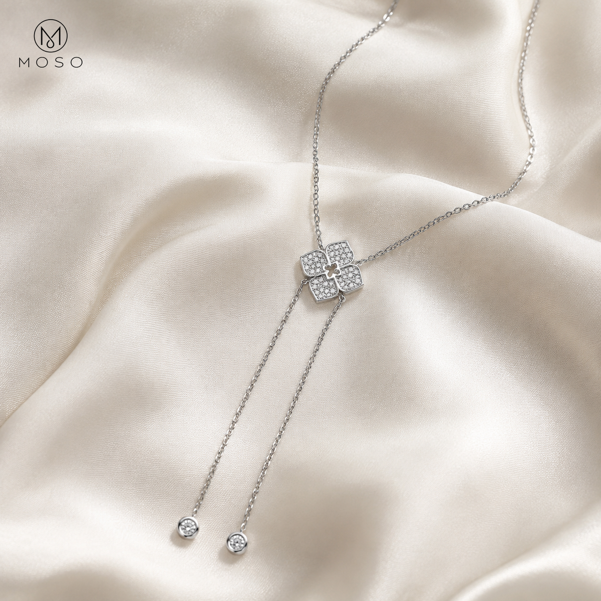 Chloe moissanite lariat necklace arranged on ivory silk