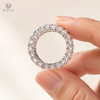 Hailey full eternity moissanite ring held between adult fingers