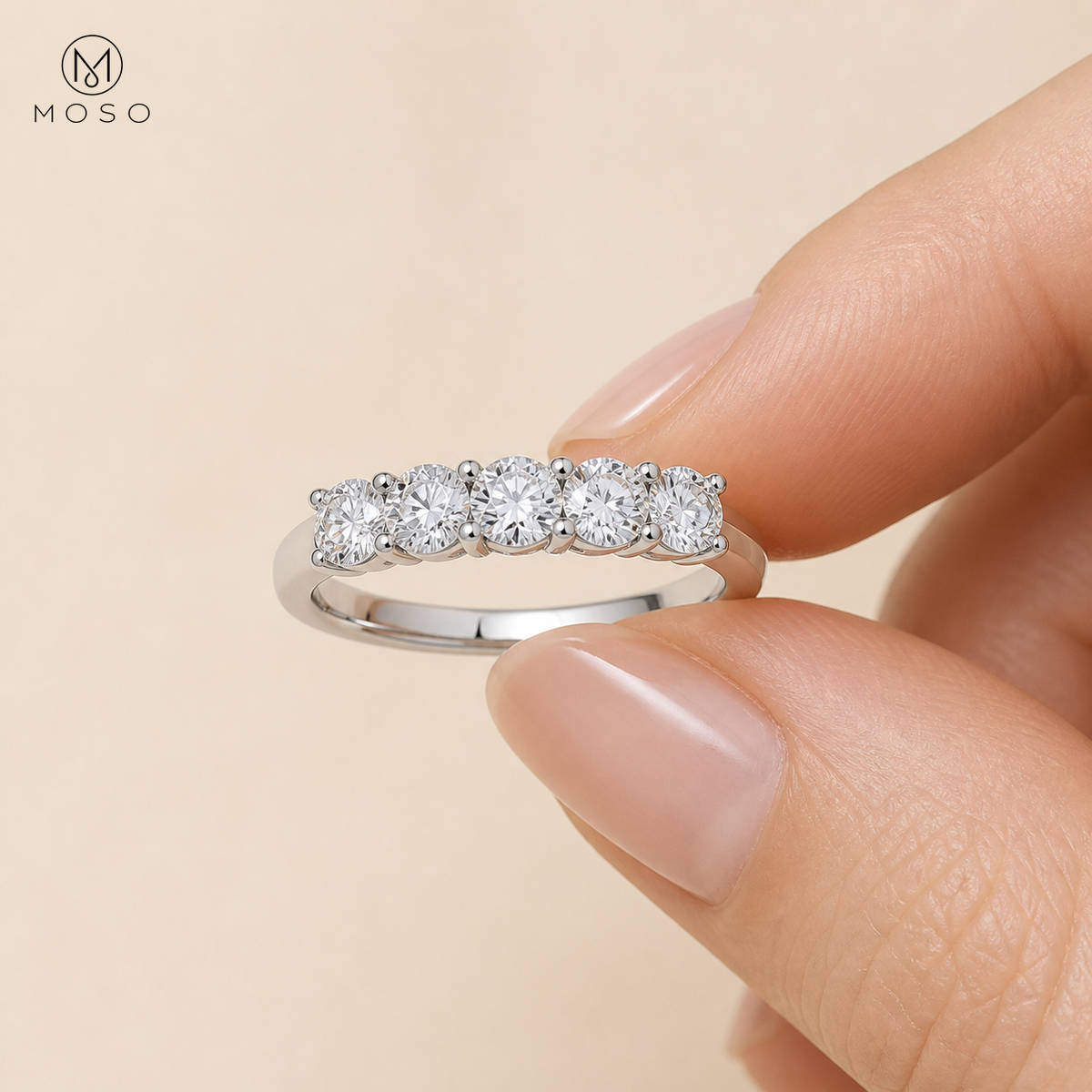 Harper five stone moissanite ring held between fingers
