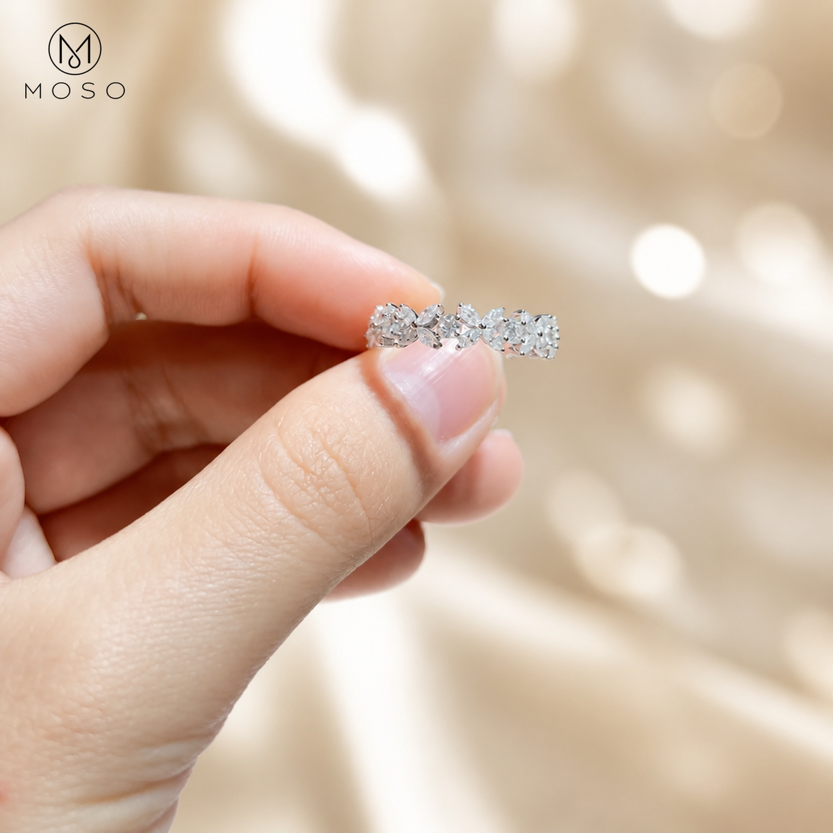 Isabella moissanite band held between fingers for scale