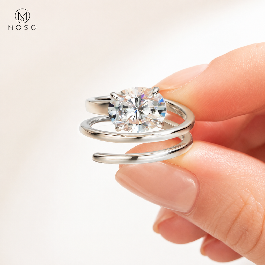 Jessica silver tone round moissanite spiral ring held between fingers