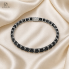 Lucy black moissanite tennis bracelet flat lay on ivory silk