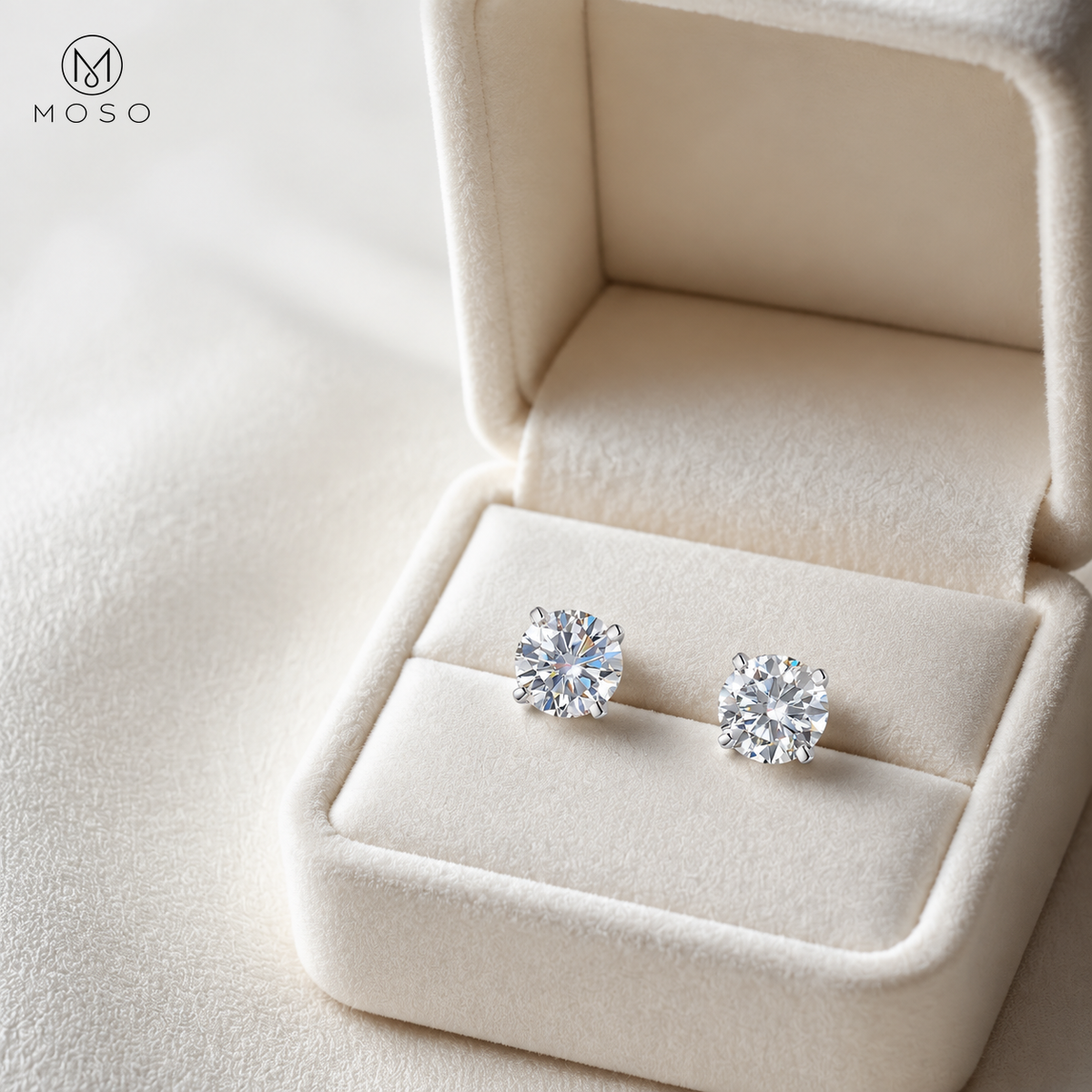 Pair of Mia round moissanite stud earrings presented in an ivory gift box