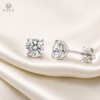 Pair of Mia round moissanite stud earrings styled on ivory silk