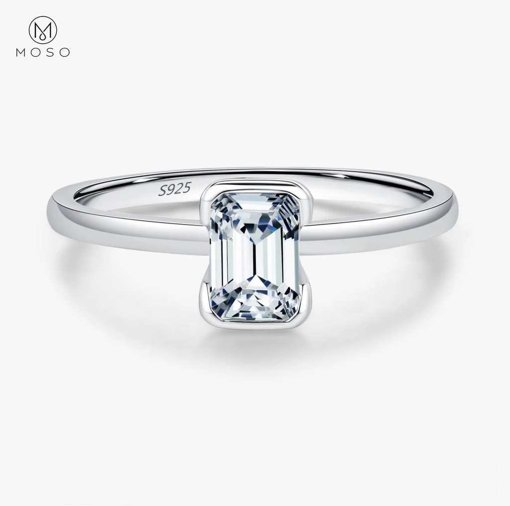 Complete emerald-cut moissanite sterling silver ring centered on a clean white background