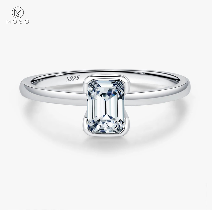 Complete emerald-cut moissanite sterling silver ring centered on a clean white background