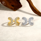 Openwork moissanite ring in yellow and white tone side by side on sand