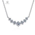 Seven round moissanite stones in a graduated necklace on a white background