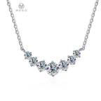 Seven round moissanite stones in a graduated necklace on a white background