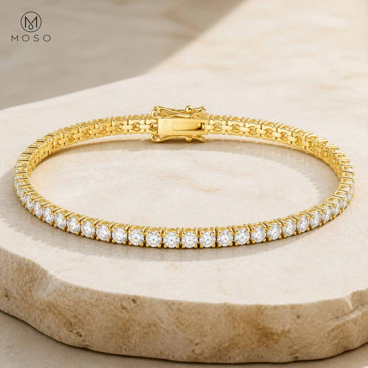 Nora gold tone moissanite tennis bracelet on stone pedestal