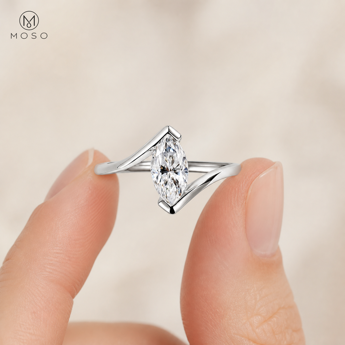 Olivia silver tone marquise moissanite ring held between fingers