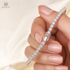 Samantha silver tone moissanite tennis bracelet held by an adult hand