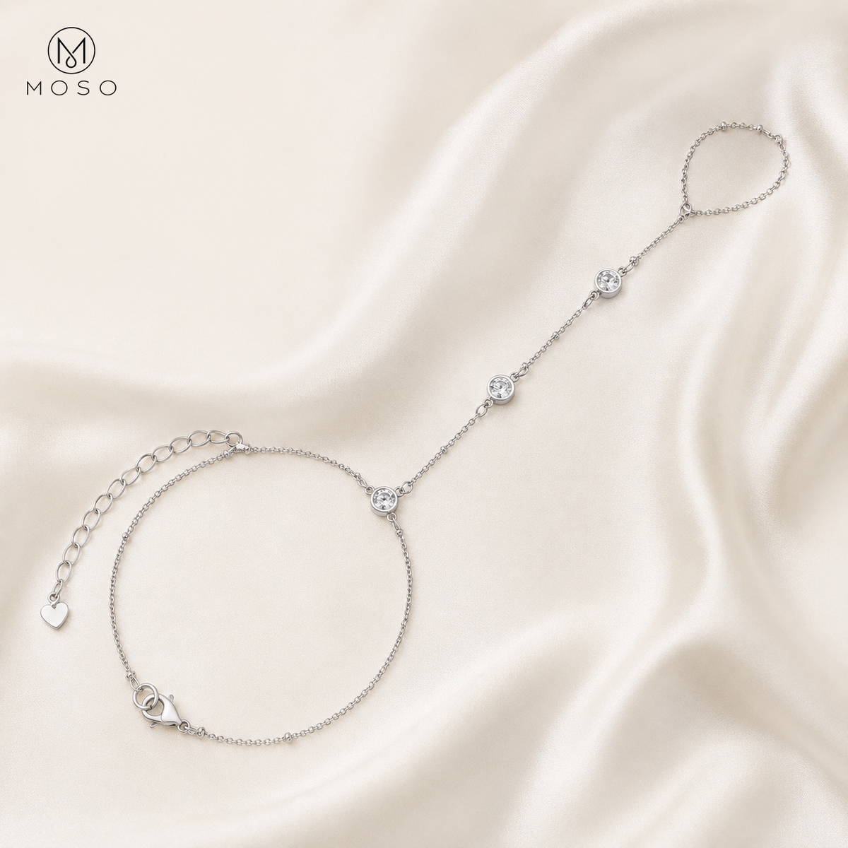 Savannah silver tone moissanite hand chain bracelet arranged on ivory silk