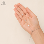 Savannah silver tone hand chain bracelet held in an adult hand showing three moissanite stones