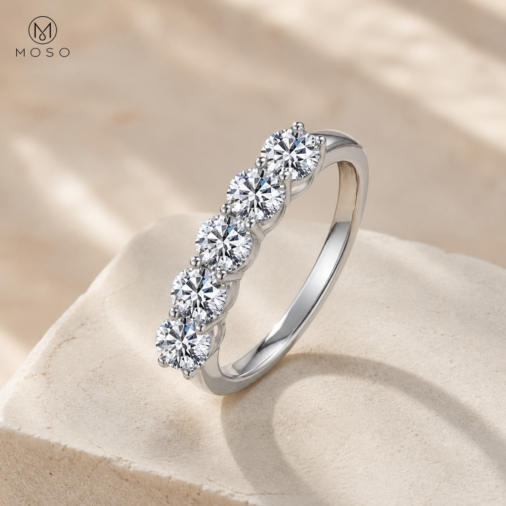 Zoe five stone moissanite wedding band on ivory pedestal